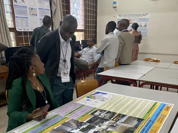 Researchers looking at a poster together in a conference room setting